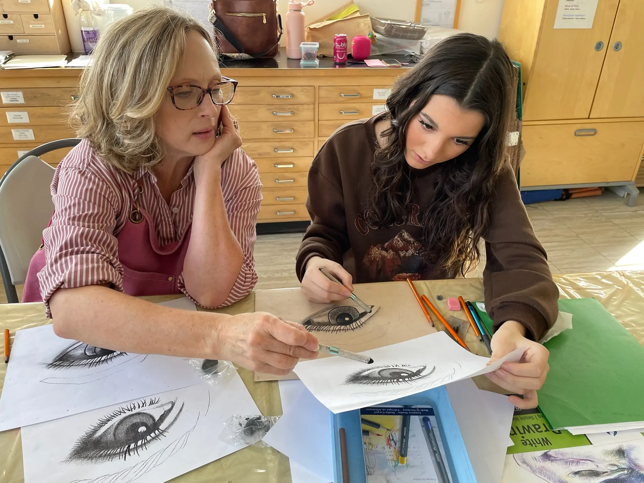 Instructor guiding a teen student through a drawing exercise during an art class at Aliki’s Art House.