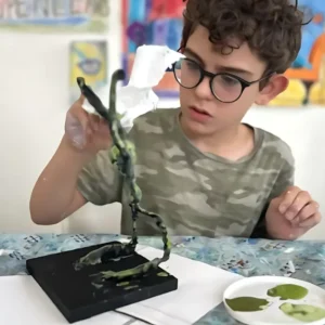 young student intently painting Giacometti armature