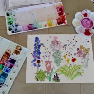 watercolour flower painting on a table surrounded by paint palettes during an adult art class at Aliki’s Art House in Calgary