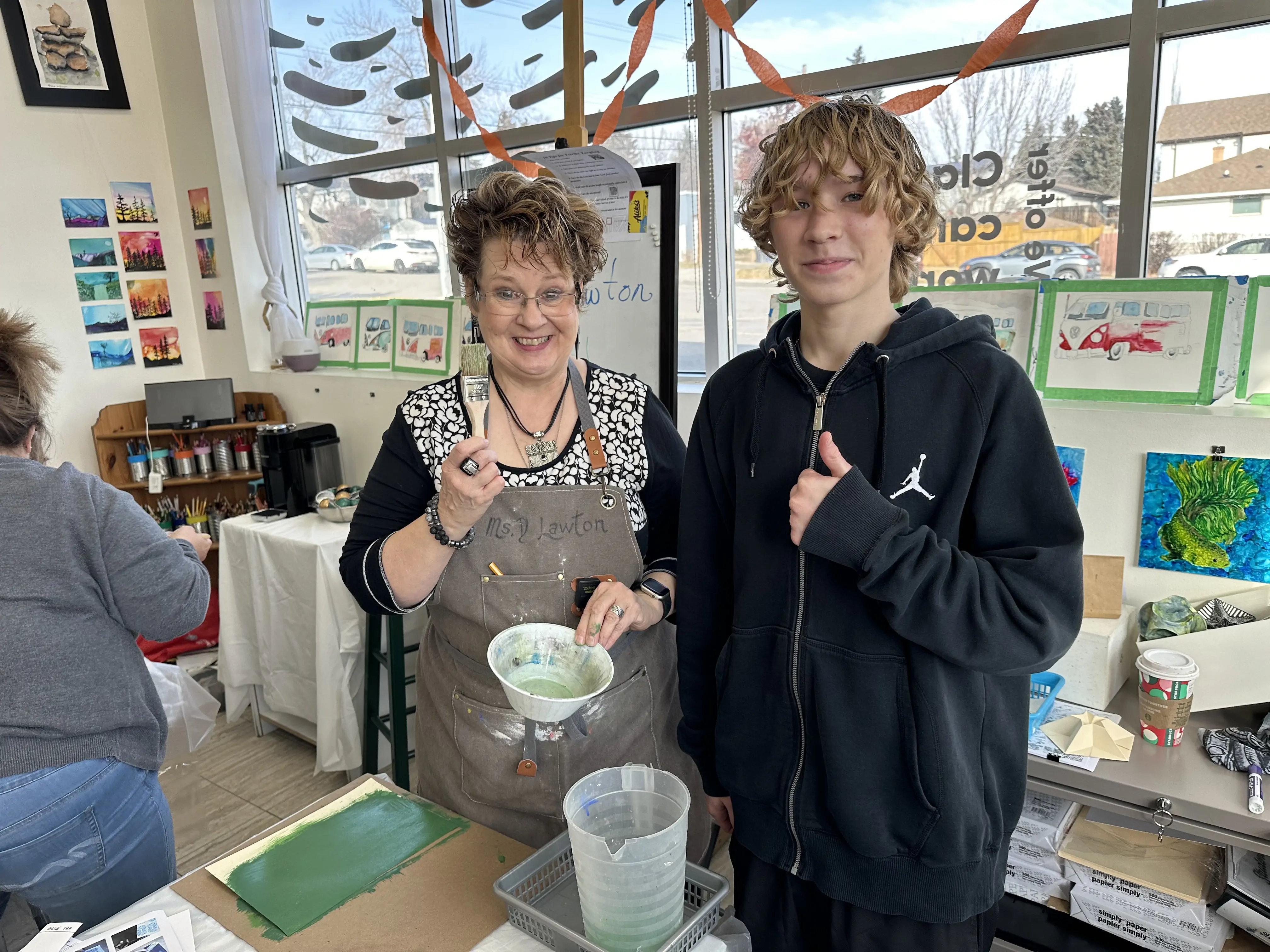 Art instructor Deborah Lawton at Aliki’s Art House in Calgary guiding a student during a painting class