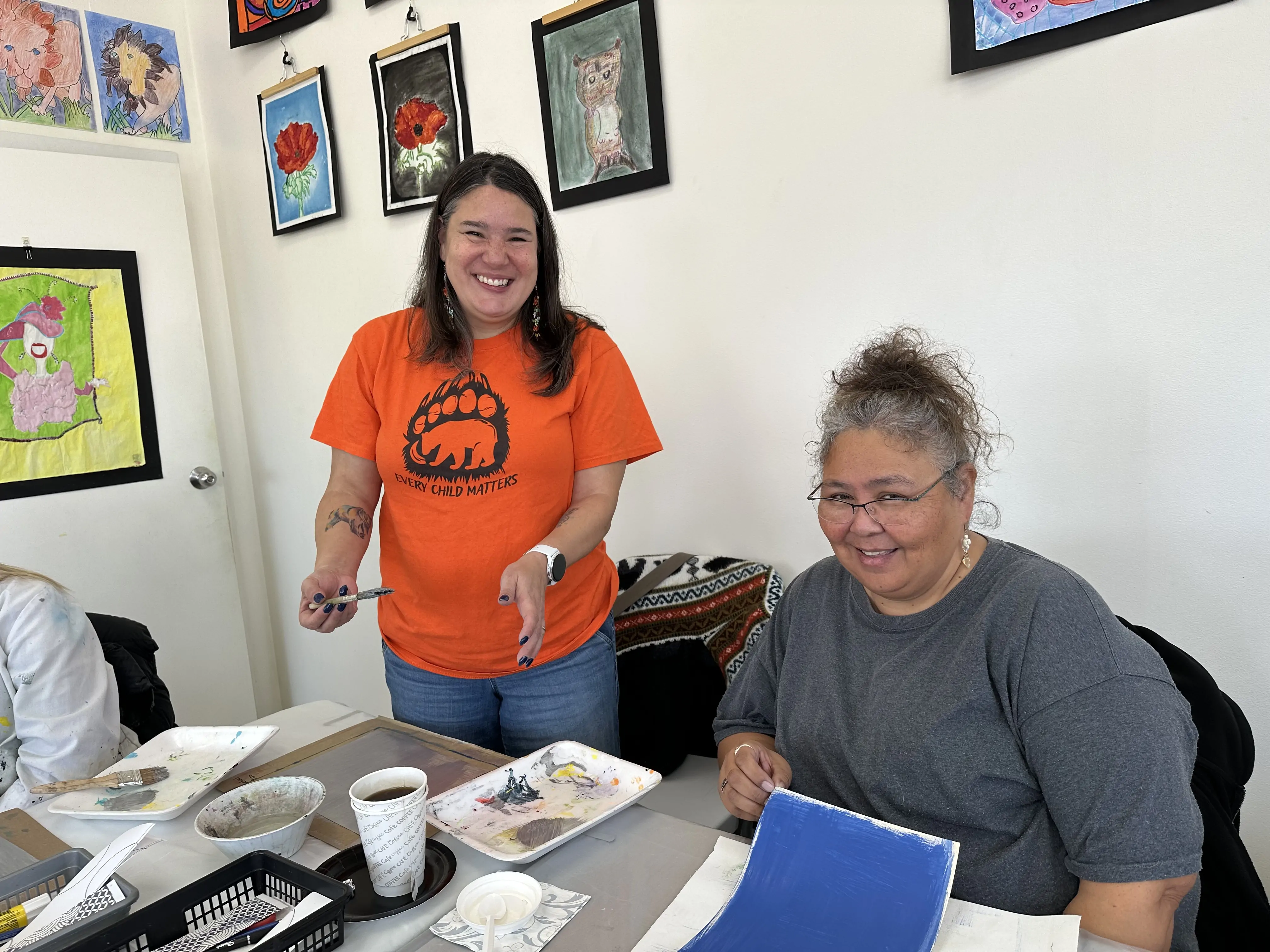 two participants smiling while working on a painting activity during an adult art workshop at Aliki’s Art House in Calgary