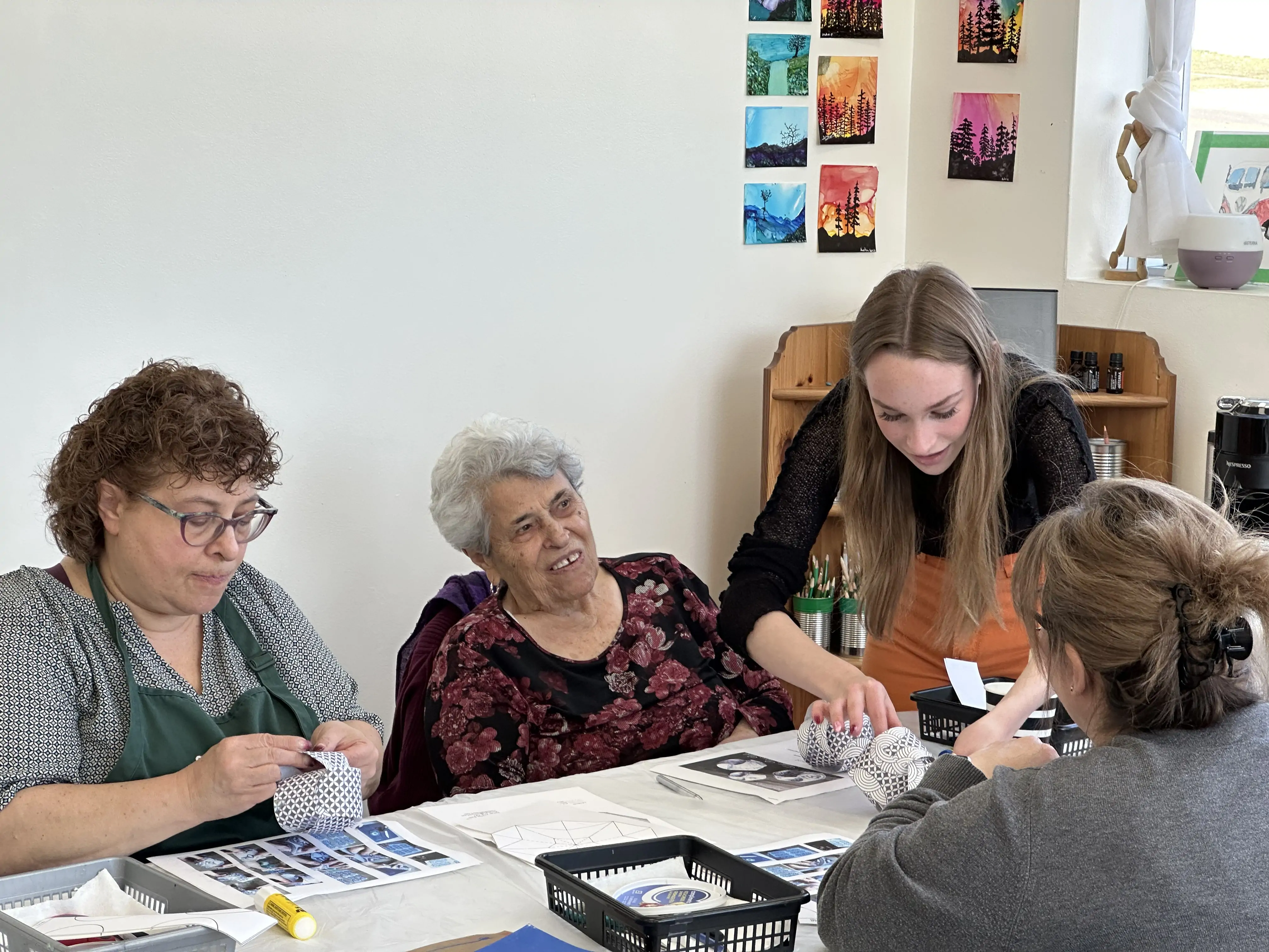 art instructor guiding adult students with paper sculpture project during a workshop at Aliki’s Art House in Calgary