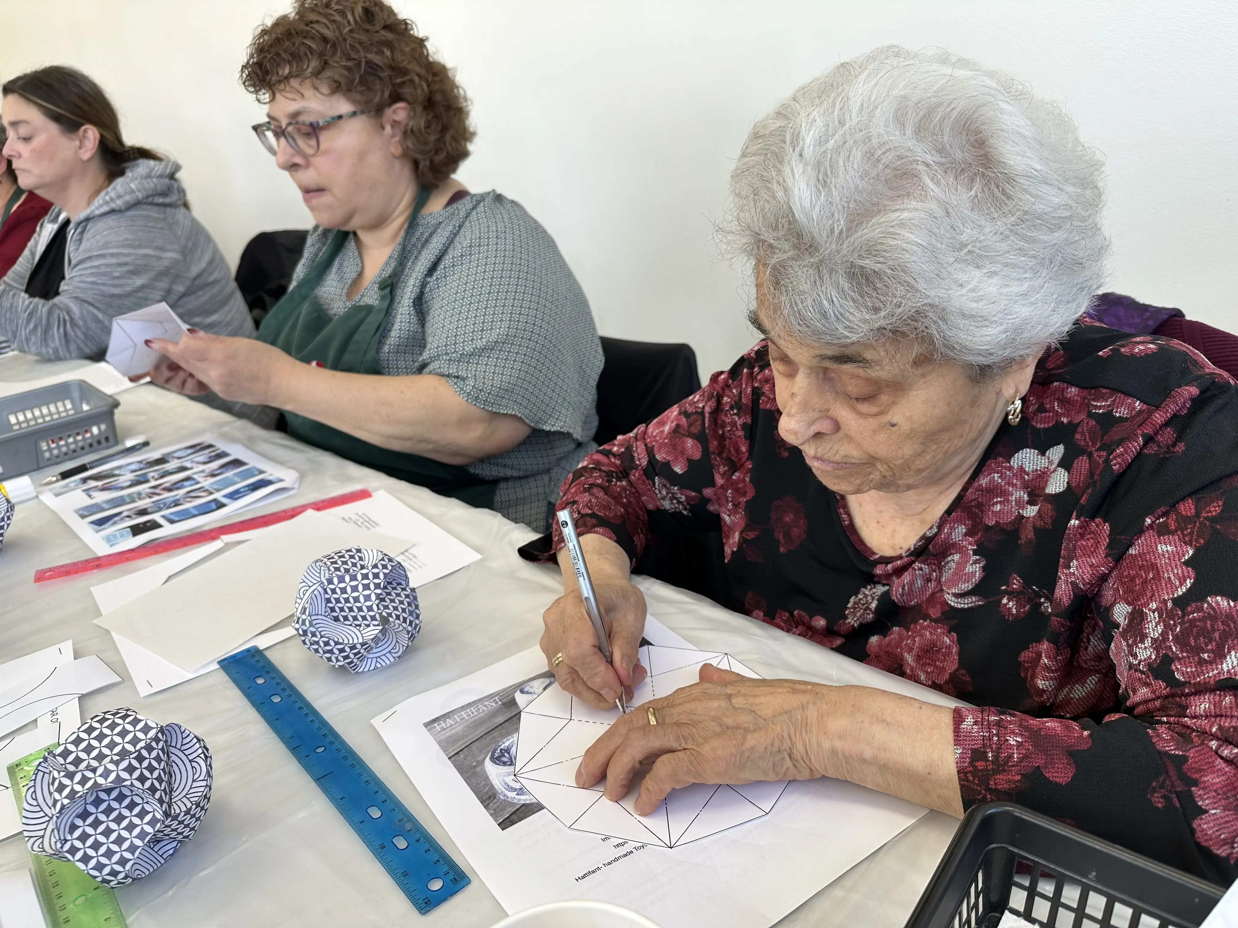 two participants working on geometric drawing and paper sculpture activities during an adult art workshop at Aliki’s Art House in Calgary